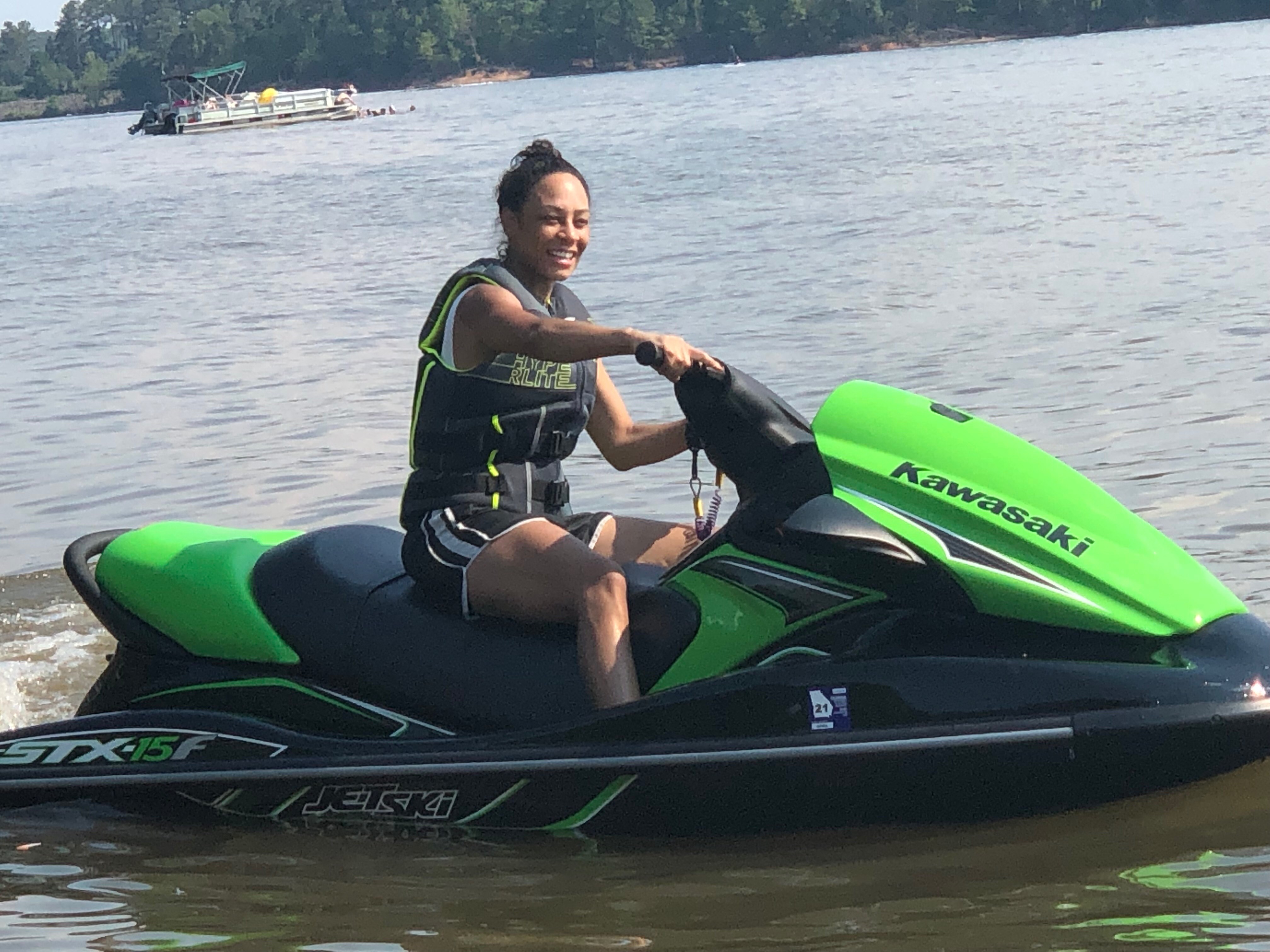 A woman is sitting on the water in her jet ski.